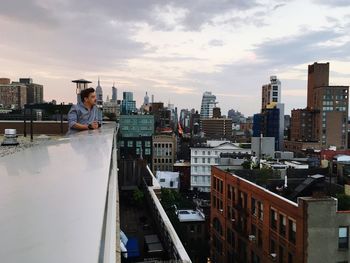 Young man standing on building terrace at manhattan