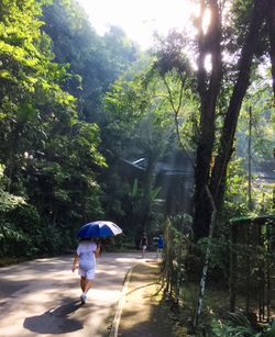 Rear view of woman walking in rain