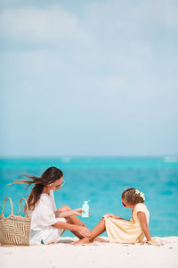 People relaxing at swimming pool against sky