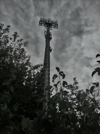 Low angle view of trees against cloudy sky