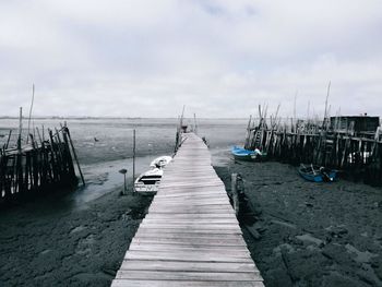 Wooden pier over sea against sky