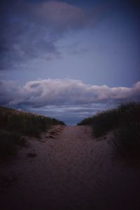 Scenic view of beach against sky at dusk