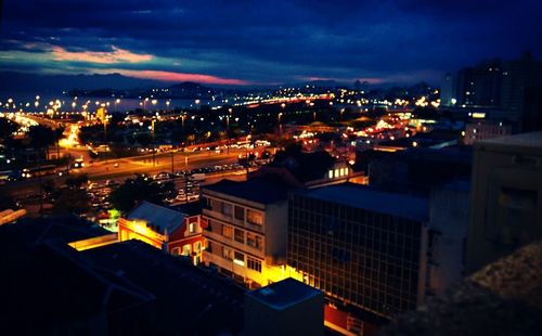 Illuminated cityscape against sky at night