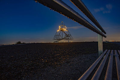 Metallic structure on beach against clear blue sky