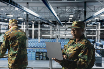 Side view of man using digital tablet while standing in city