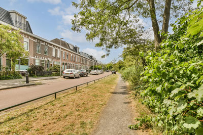 Empty road amidst buildings in city