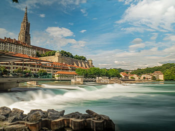 Arch bridge over river against buildings in city