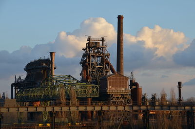 View of factory against cloudy sky