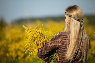 Rear view of woman standing on field