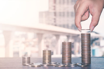 Close-up of hand holding black and stack of metal