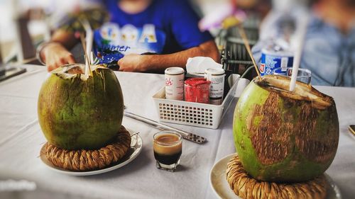 Close-up of hand holding drink served on table