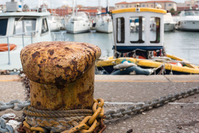 Close-up of rope tied to bollard at harbor