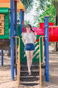 Portrait of smiling woman standing on slide