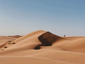 Sand dunes in desert against clear sky