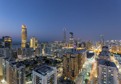 Illuminated buildings against sky in city