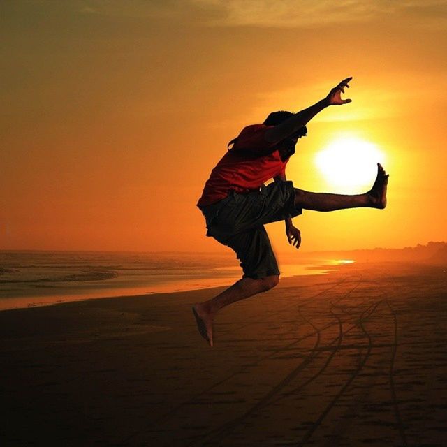 SILHOUETTE OF WOMAN IN SEA DURING SUNSET