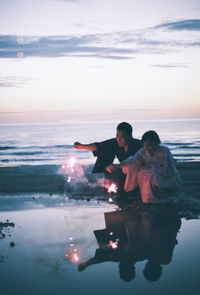 Full length of friends at beach against sky