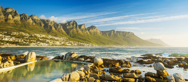 Scenic view of sea and mountains against sky