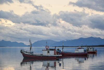 Boats moored in sea against sky