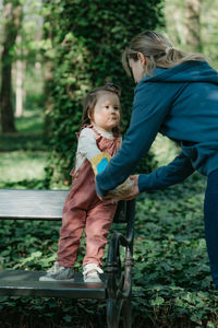 Full length of mother and daughter standing in park