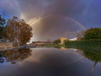 Scenic view of rainbow over lake against sky