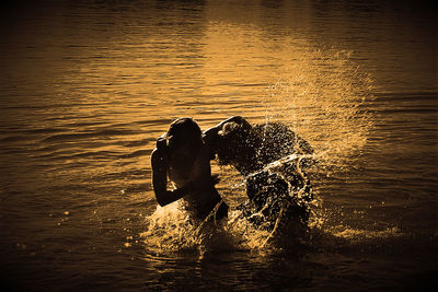 Man swimming in sea during sunset