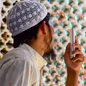 Close-up portrait of man holding smart phone