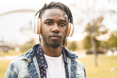 Portrait of young man with headphones standing in city