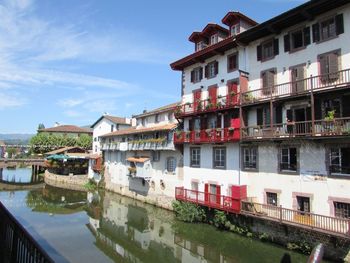 Buildings by lake against sky in city