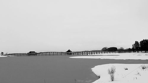 Scenic view of lake against clear sky during winter