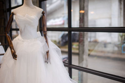 Close-up of white dress in display at shop for sale