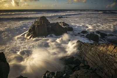 Scenic view of rocks in sea against sky