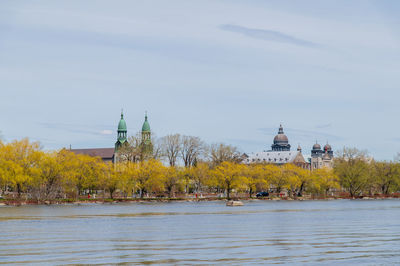 Scenic view of river by building against sky