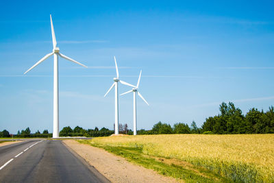 Windmills along the road against the blue sky