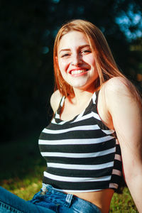 Portrait of smiling young woman sitting outdoors