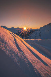 Scenic view of snowcapped mountains against sky during sunset