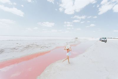 Woman on beach against sky