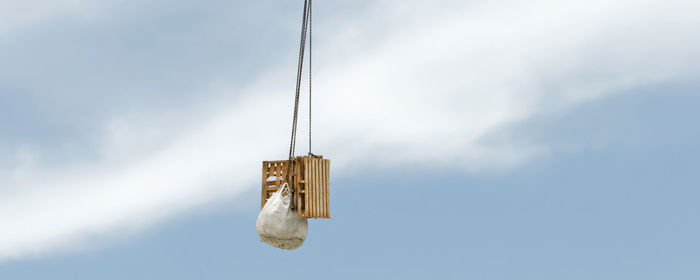 Low angle view of rope hanging against sky