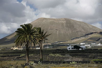 Scenic view of landscape and mountains against cloudy sky