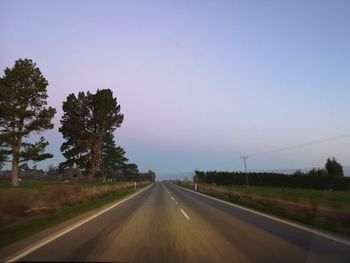 Road amidst trees against sky