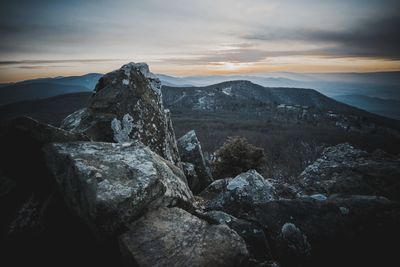 Rock formation on landscape against sky during sunset