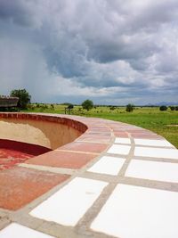 Empty road against cloudy sky