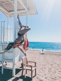 Full length of woman performing aerobics at beach