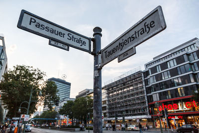 Road sign against sky in city