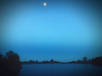 Scenic view of lake against clear sky at night