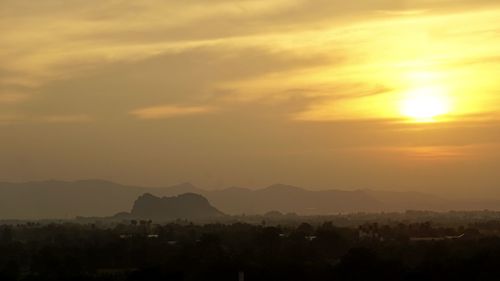 Scenic view of silhouette mountains against orange sky