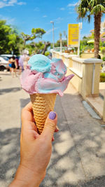 Gelato ice cream cone held up to the hot summer city