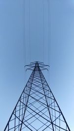 Low angle view of electricity pylon against clear sky