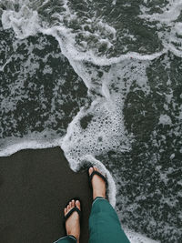 Low section of person standing on beach