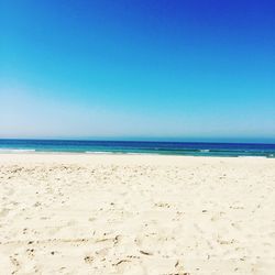 Scenic view of beach against clear blue sky